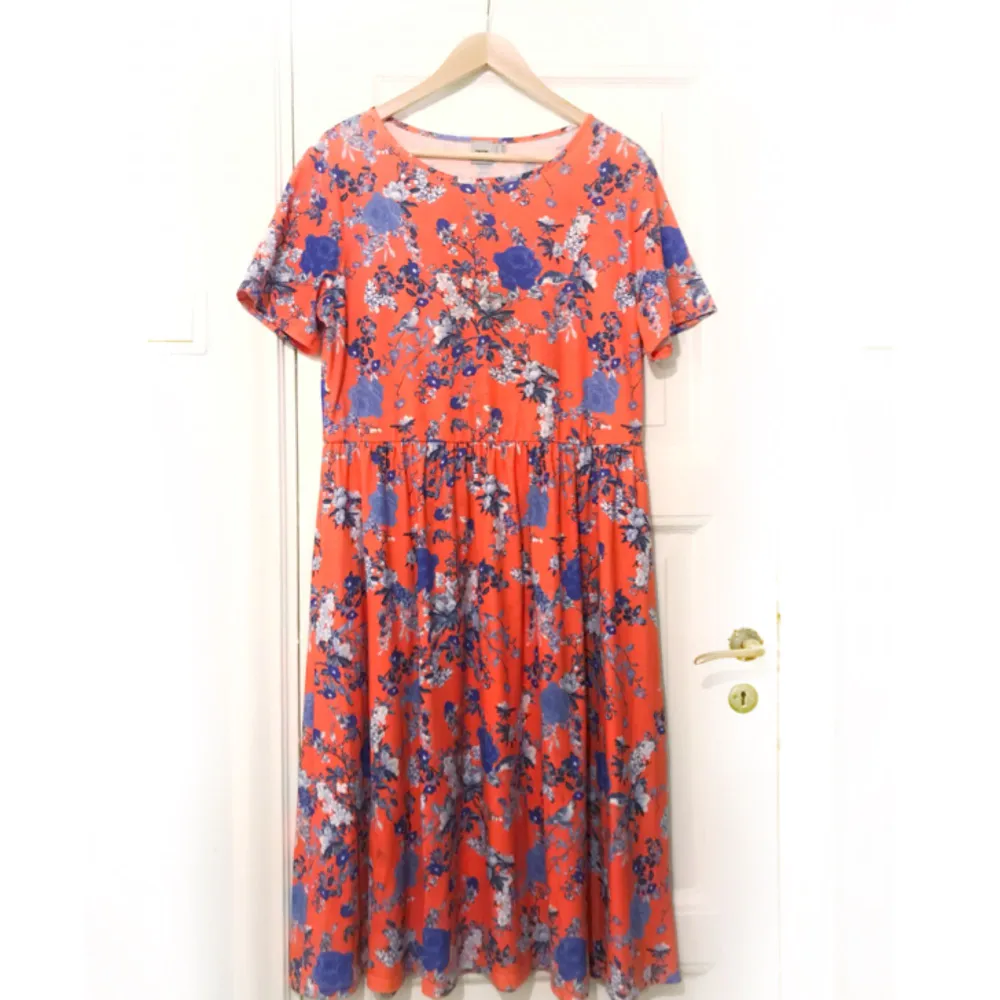 Halvlång röd/orange klänning i bomull från Asos med blommigt blått mönster. Använd en gång. . Klänningar.
