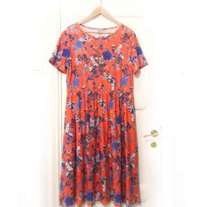 Halvlång röd/orange klänning i bomull från Asos med blommigt blått mönster. Använd en gång. 