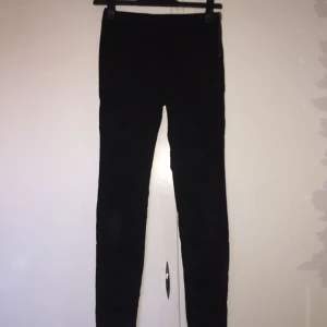  - Svarta tighta byxor från h&m med semi-hög midja. Guldig dragkedja på vänster sida. Nästan aldrig använda. Strl 34.