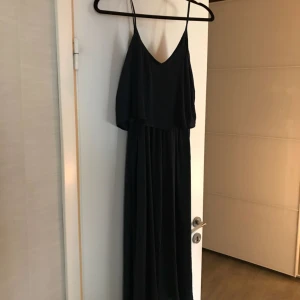  - Jättefin sommarklänning. Den är mörkblå och materialet är i silke. 