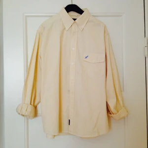 Vit/gul randig skjorta från Colonial. Sjysst passform för medelstor kille. - Vit/gul randig skjorta från Colonial. Sjysst passform för medelstor kille.