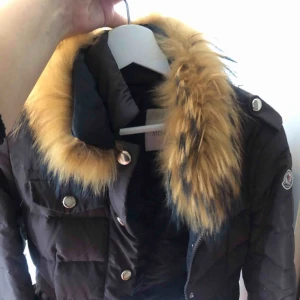 - Moncler jacka brun med pälskrage. Använd ganska mycket därav pris. Kostade 3000 ny. 