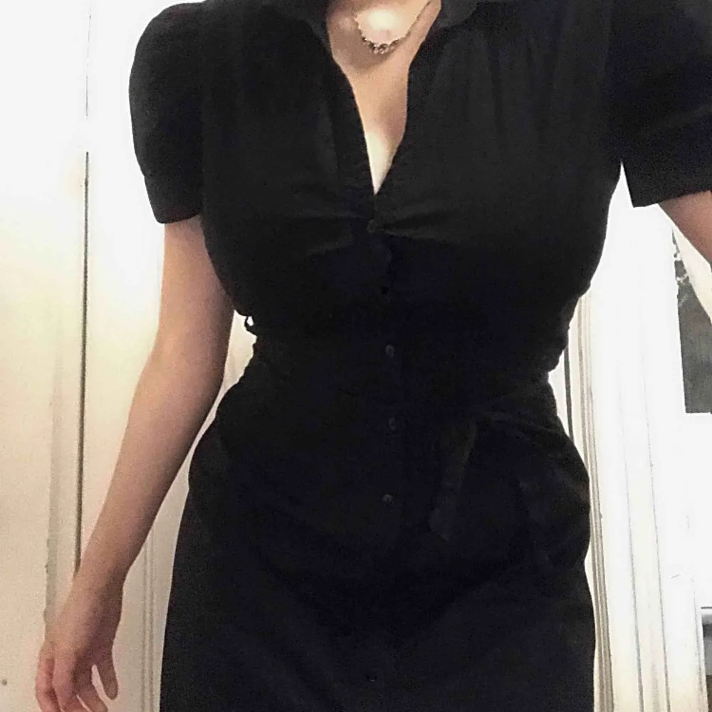 Medellång, svart skjortklänning med knappar och ett skärp att knyta! Jättesöta puffärmar 👸 . Klänningar.