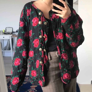  - Svart jacka med röda rosor, strl L. I bra skick med endast tre knappar kvar, går att fixa. Kan skicka bilder