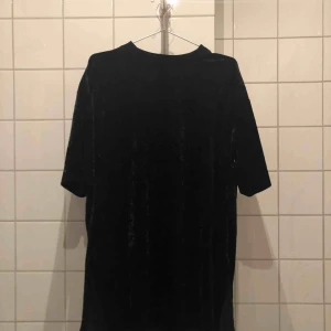  - Svart klänning i sammet med slits på båda sidorna
