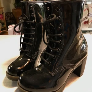 Doc Martens känga, lack, stl 36 - Ett par nästan sprillans nya Doc Martens känga i lack. Fantastiskt vacker och mycket svår att få tag i. Köpta i London för ett par år sen. Storlek 36, klack 8cm, höjd bak 24cm, 16hål. Orginalsnörning. Ingen låda, behövde platsen. Kan ha en annan Doc-låda om jag letar. De sitter fantastiskt bra. Lack är King!