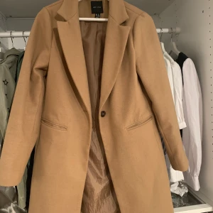 Kappa från Nelly - Beige kappa från Nelly i storlek 36.