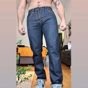 Nudie Jeans  - 100% Oragnic cotton "RAW Jeans" Steady Eddie Tvätt Tonal Dry Jeans som har knappt används Dessa "Bad Boys" behöver hitta en ny ägare. De har blivit tvättade så det är lite mjukare än vad man får dem i butik men riktigt härliga! W32 L Uppsydd modell: 170 cm 