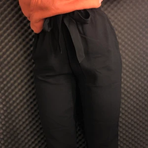 Kostymbyxor med knytning - Ett bra snygga kostymbyxor med knytning vid midjan. Bra skick o väldigt sköna. Stl 34 köpta från Na-KD. Frakt ingår