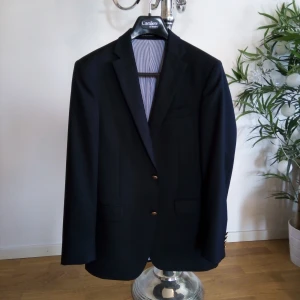 Kavaj från Oscar Jacobson - Så snygg 😍 kavaj/blazer från Oscar Jacobson, väldigt bra passform, använd vid ett tillfälle sen har gubben min växt ur den 😅 så nu hänger den bara i klädförrådet och väntar på en ny ägare 😉. Den är helt svart och fodret är vitt och blått kritit med bruna detaljer vid innerfickorna. Den är perfekt att glänsa med i sin stilrenhet, bara ett par jeans och en snygg piké till så är det klart 👌 Passar överallt, olika tillställningar, fest och bröllop 💯  Den är köpt på CareOfCarl för 3499kr och den är som ny 🌟 så passa på, säljer den endast för 500kr 😃 storlek 48/M Finns i Västerås 🌸