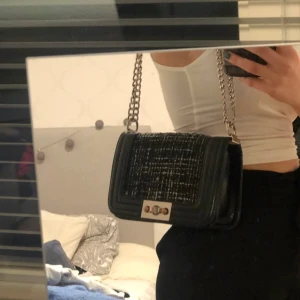 Väska från Gina tricot - Svart och vit väska. Går att justera bandet kort såsom jag har på bilden eller längre. Banden är inte riktigt lika silvriga som förr men ändå fina.
