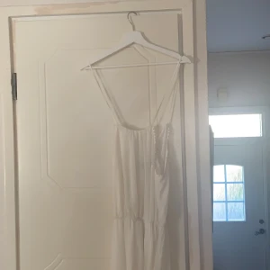 Bikbok XS - Lång vit klänning, använd en gång. Mycket bra skick. Krämig färg. Köptes för c.500. Kan användas som skolavslutning, vardag, finklädd. 