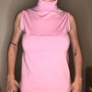 Rosa topp, Dolce & Gabbana - Supersnygg rosa topp med polokrage från Dolce&Gabbana (ej äkta). Står att det är storlek M/L men skulle säga att den passar S/M beroende på hur man vill att den ska sitta. På sista bilden har jag knutit den bak. Kan även posta, pris ex. frakt