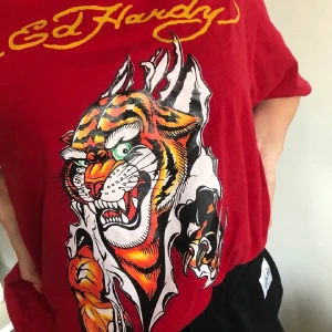 EdHardy t-shirt - Superfin Ed Hardy t-shirt, säljes då den inte kommer till användning. Storlek L men skulle säga passar de flesta beroende på hur man vill att den ska sitta 🥰 Hör av er vid frågor eller för fler bilder!