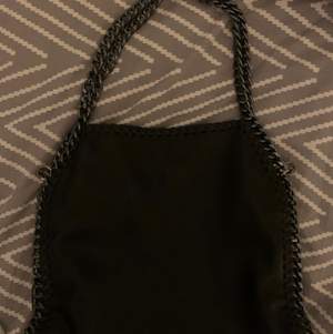 En svart väska som liknar Stella Mccartney väska den är ganska väll använd! Väskan går att matcha till många outfits! 150 kr + 63 kr frakt!