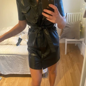 Läder klänning från bik bok strl S - Fin klänning som passar till fest, använd en gång. En knapp är lite trasig dock den tredje nerifrån men inget man märker. Säljes pga inte får den till användning. Kostar 150kr plus frakt.