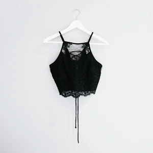  - Svart linne med svart brodyr framtill och knytning i ryggen. 