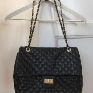 Fin quiltad svart Chanel-lookie väska som går att bära på två sätt tack vare den dubbla axelremmen.  Köparen står för frakt!