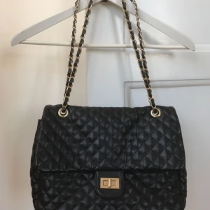  - Fin quiltad svart Chanel-lookie väska som går att bära på två sätt tack vare den dubbla axelremmen.  Köparen står för frakt!
