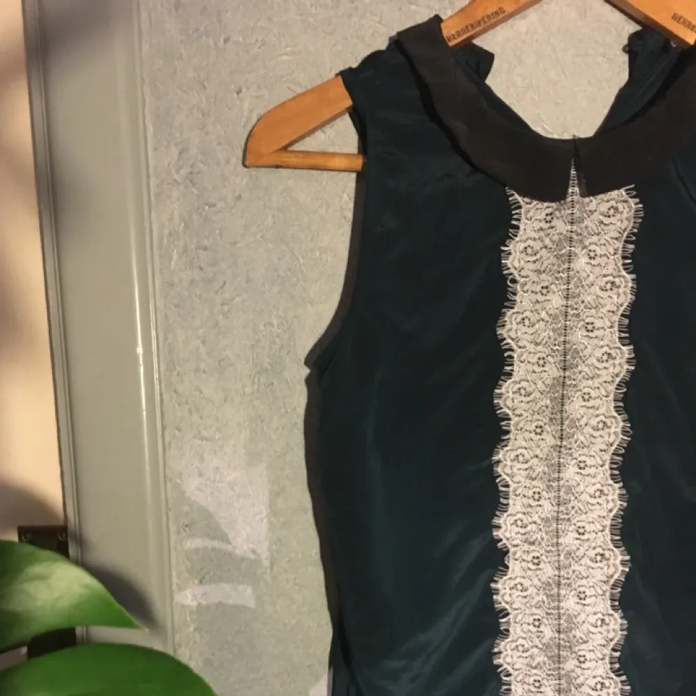 Superfin mörkgrönt linne med vit spets och svart krage, silkigt material (polyester) från Lindex  . Skjortor.