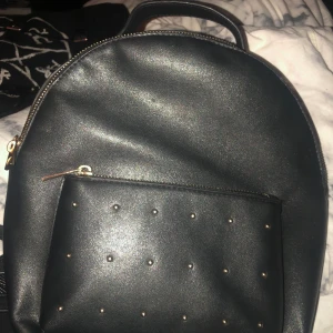 Svart ryggsäck  - Liten svart läder (osäker på om det är äkta) ryggsäck. Frakt får man stå för själv se hela priset blir 84. Finns små fläckar inuti.