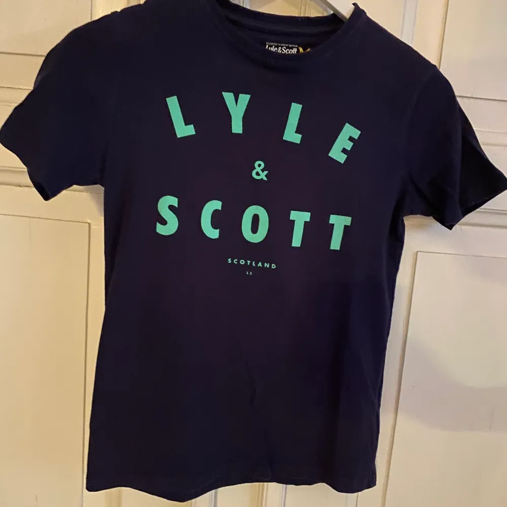 Mörkblå lyle & scott t-shirt i storlek 12/13 år. T-shirt är i bra skick, frakt tillkommer. . T-shirts.