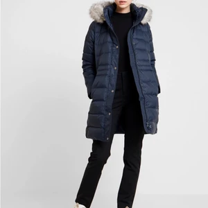 Vinterjacka Tommy Hilfiger, NYSKICK - Säljer dunjacka, modell lång. Prövad vid 3 tillfällen i slutet av februari 2019. Men stilen passade inte mig, sen dess har den hängt orörd. Dunfylld kappa med hög krage och luva. Jackan stängs med dragkedja och tryckknappar, jackan har två sidofickor. Ribbade muddar i ärmslut och Tommy Hilfiger-logga på ärmen. Längd till låren. Nypris 3500kr , bud från 500kr. Köparen står för frakten. Pris kan diskuteras 