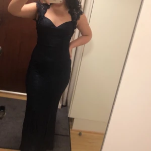 Mörkblå festklänning - Mörkblå lång festklänning från Nelly med öppen rygg, endast använd 1 gång, i jätte fint skick! Har råkat klippa bort storlekslappen men skulle säga att den är i S/M