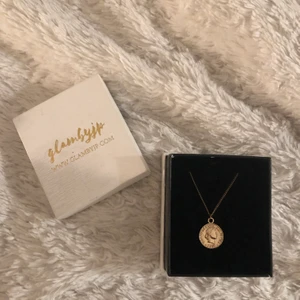 Guldigt halsband  - Guldig kedja med ett mynt på från glambyjp, NYPRIS 170kr, använd fåtal gånger är i nyskick, kan fraktas, frakt ingår ej i priset 