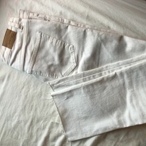 Vita ankellånga jeans  - Vita jeans från Gina Tricot med slitningar i anklarna 