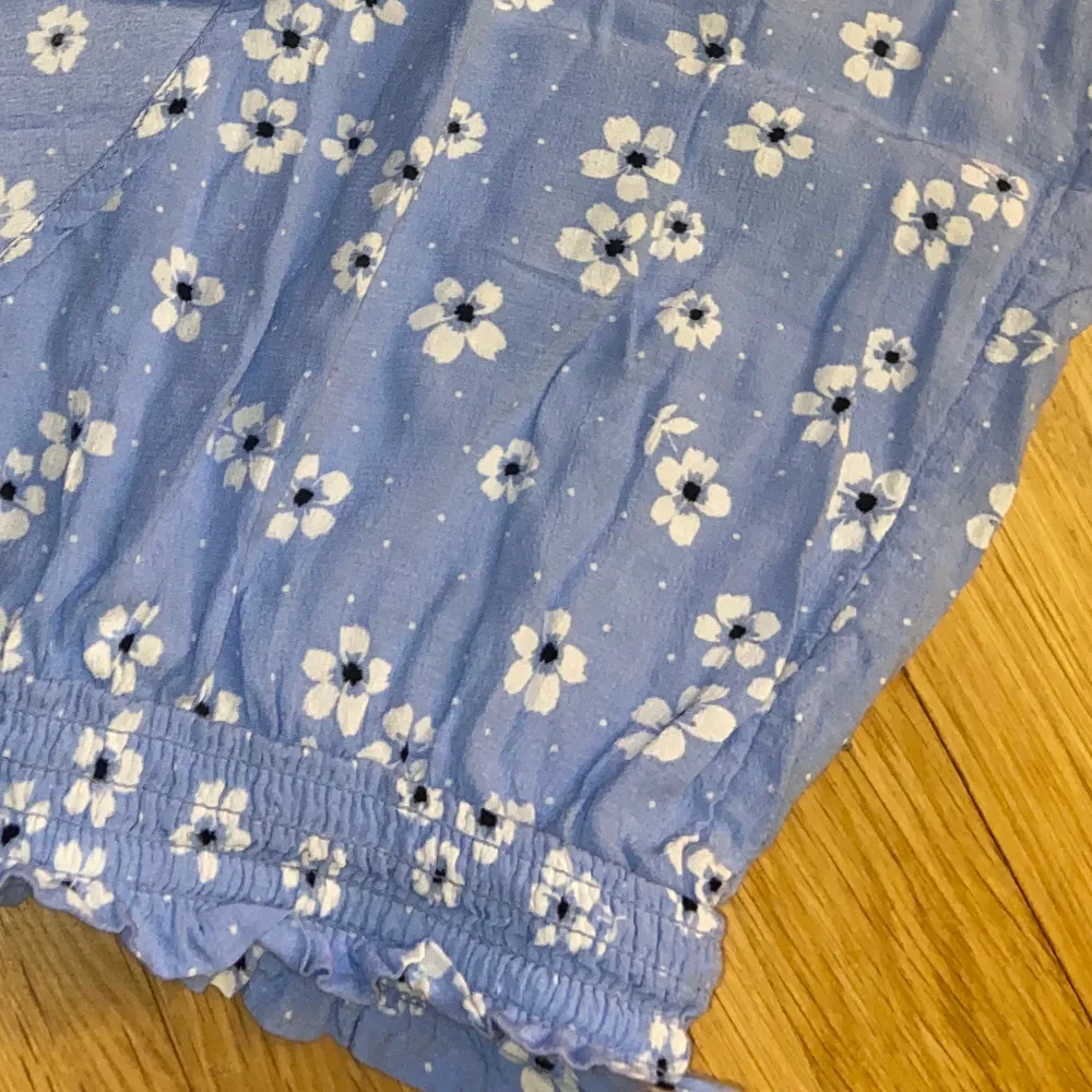 Supersöt ljusblå kjol från Monki. Små vita blommor och fejk-omlott. Passar XS-M då den har bra resor i midjan💖. Kjolar.