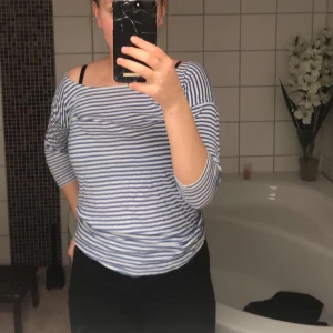 Blå-vit randig tröja - Trekvartsärmad tröja blå och vit randig. Säljer för att den sitter konstigt på mig över bröstkorgen. Använt den max 5 gånger. Väldigt skönt material, speciellt på sommaren. 