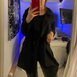 Kappa  - En skitsnygg svart kappa/trenchcoat!! Har kommit mycket till användning men är fortfarande i bra skick. Passar verkligen till allt!!! Den går ner till lite över knäna på mig ungefär och jag är 159 cm lång. Kommer med ett band i samma tyg man kan sätta i öglorna i midjan och dra åt! Hör av er om ni har frågor!💕💕💕💕
