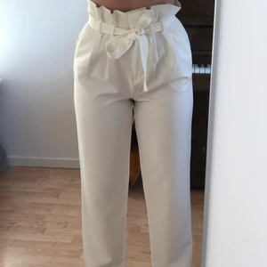 Vita kostymbyxor  - Vita kostymbyxor från BikBok med fickor och knytning midjan. Endast använda en gång. Storlek XS men passar även S. Köparen står för frakten.