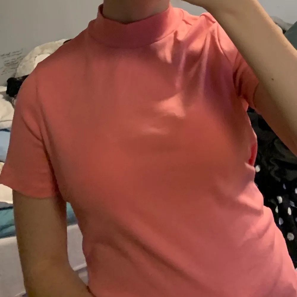 En lys-rosa t-shirt som har en kort ”krage”. Den är i nyskick, bara andvänd ett fåtal gånger.☺️ OBS!! Köparen trår för frakten!!💕. T-shirts.