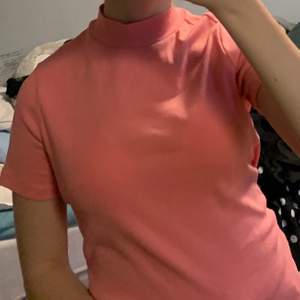 En lys-rosa t-shirt som har en kort ”krage”. Den är i nyskick, bara andvänd ett fåtal gånger.☺️ OBS!! Köparen trår för frakten!!💕