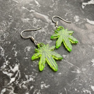 Cannabis örhängen  - Säljer två par av dessa sjukt coola cannabis örhängen från shitshop här på Plick  :) De är väldigt små i verkligheten, jämförelsevis ungefär som en tvåkrona. Köparen står för frakten. Skriv till mig för fler bilder 🥰 pris kan diskuteras