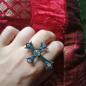 Superfin ring med ett kors i mörkgrå detaljer med stenar i blått o genomskinligt💙 sitter på två fingrar! Frakt ingår💜