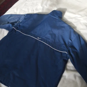  - Fet jacka ifrån Nike, lite 90-s stuk på den. Lite skador vid högra hörnet längst ner på baksidan av jackan, men inget man tänker på!! 