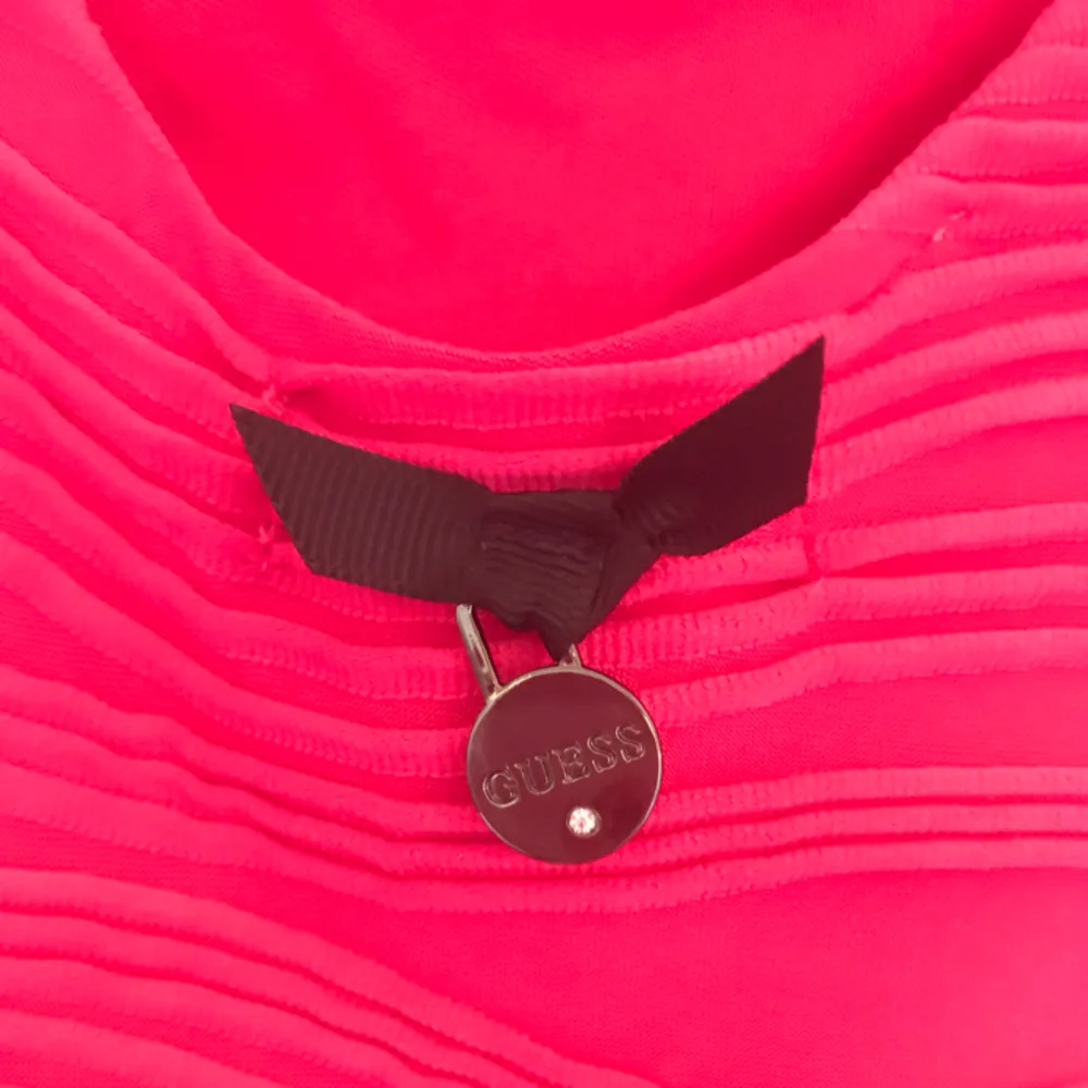 Helt ny och oanvänd rosa klänning från märket Guess, inköpt i en Guess-butik i USA. Klänningen är jättesnygg och formgivande, passar perfekt till fest. Prislappen är inte kvar, men den lilla Guess-berlocken hänger fortfarande kvar i ryggen (se bild).. Klänningar.