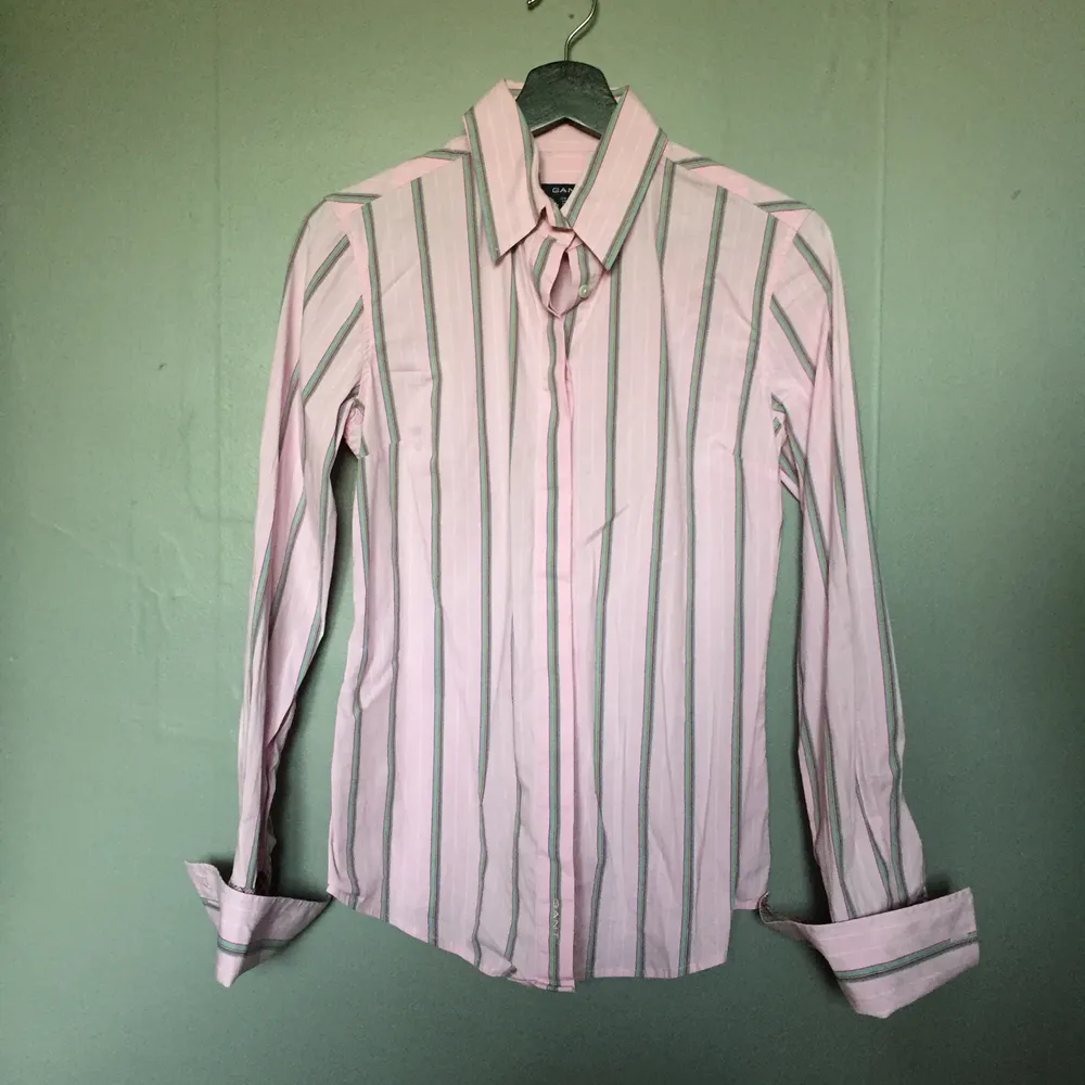 Rosa skjorta med flerfärgade ränder från Gant. Aldrig använd och superfint skick. Jag säljer den för att jag aldrig använt den 🌻 köparen betalar frakten. Skjortor.