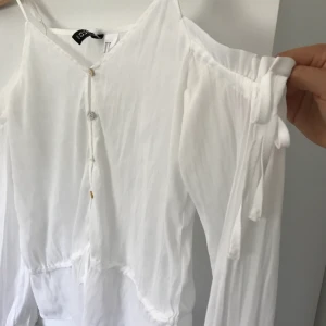  - Vit blus/off shoulder från H&M, använd en gång så i väldigt bra skick. Finns även band att använda så blusen blir som ett linne. 