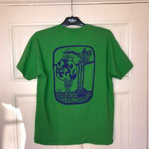 En grön T-shirt från Skatemärket Polar med ett coolt ryggmotiv. Sparsamt använd