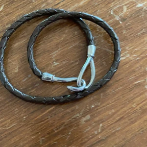 Armband  - Snyggt armband i brunt fusk skinn snurras två varv. Längd 39 cm. Frakt tillkommer 15kr