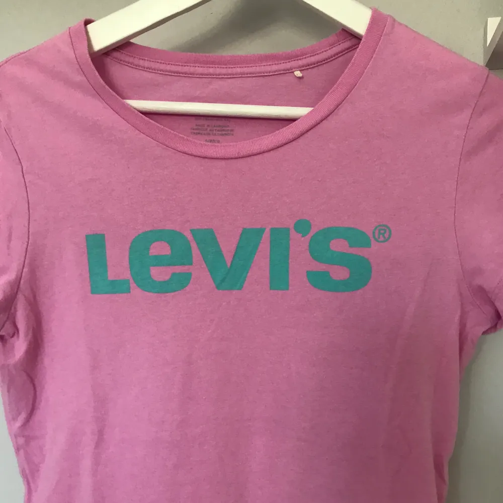En T-shirt från Levis som är ljusrosa och pastell blå i storlek S. . T-shirts.