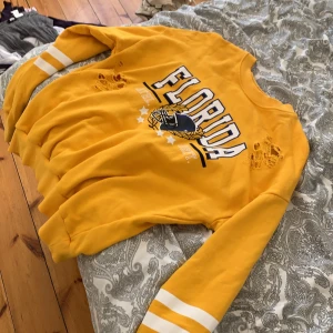 Gul tjock tröja - En gul tjock tröja där det står Florida på. 