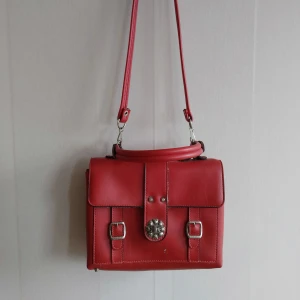 Röd Vintage väska - Röd Vintage väska. Den har ganska många år bakom sig men är fortfarande i okej skick. Säljs då den inte används längre.  