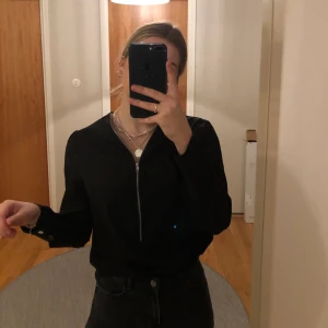 Svart blus - Jättefin svart blus med dragkedja detalj upptill. Mycket bra skick. Frakt ingår i priset 