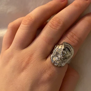 Ring i silver, döskalle och orm - Säljer denna skitcoola ring i silver med en döskalle och orm på. Har en liten skråma som man kan se på sista bilden. Ringen rostar ej. Köpte vintage för 60kr så säljer för 40kr. Frakt tillkommer!❤️ skriv gärna om du har frågor eller vill ha fler bilder.