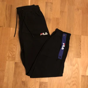 Fila byxor storlek M - Svarta Fila byxor med snygga detaljer. Storlek M. Går att öppna längst ner vid benen med dragkedja. 